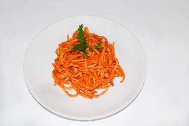 Beyaz arka planda yuvarlak tabakta spagetti bolonez.