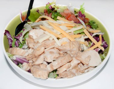 Malzemeler beyaz arka planda bir kaseye tavuk sarmaya hazırlanıyor.