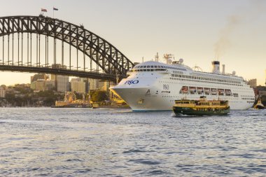 Luxury cruise ship near Sydney Harbour Bridge at sunset clipart