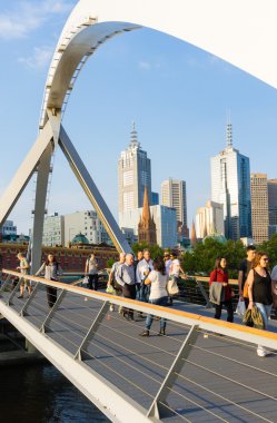 Melbourne Southgate yaya köprüsü üzerinde yürüyen insanlar