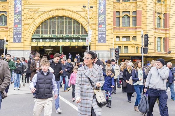 Mensen oversteken van de straat buiten de Flinders Street Station in Melbourne — Stockfoto