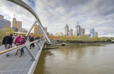 Melbourne Southgate yaya köprüsü üzerinde yürüyen insanlar