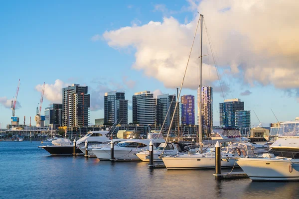 Yachts dans la marina et des bâtiments résidentiels modernes à Melbourne au coucher du soleil — Photo