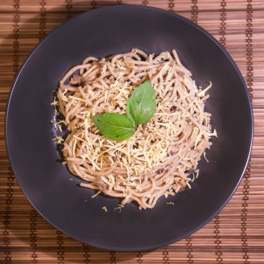 Fesleğenle süslenmiş mantar soslu vejetaryen spagettileri.