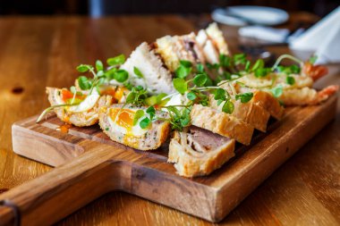 Tahta tabakta İskoç yumurtası ve sosis rulosu. Bir restoranda, ahşap bir masada..