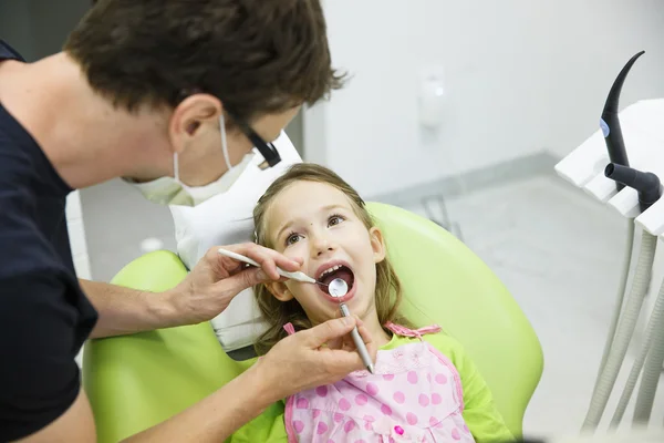 Menina sentada na cadeira dentária em seu check-up dental regular — Fotografia de Stock