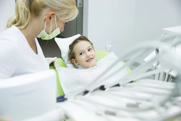 Mały pacjent rozmawiając z jej dentysta — Zdjęcie stockowe