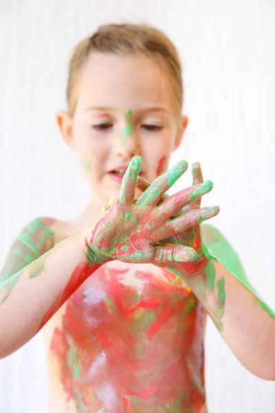 Kleines Mädchen mit Händen, die mit Fingerfarbe bedeckt sind — Stockfoto