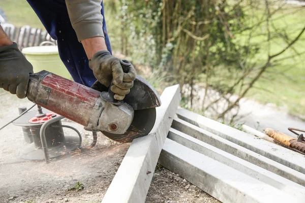 Byggnadsarbetare skära en armerad betong pelare — Stockfoto