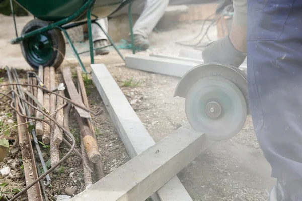 Trabalhador da construção cortando um pilar de concreto armado — Fotografia de Stock