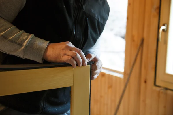 Trabajador que se prepara para instalar nuevas ventanas de madera de tres paneles — Foto de Stock