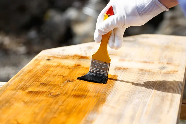 Maler bemalt Holzoberfläche, schützt Holz — Stockfoto