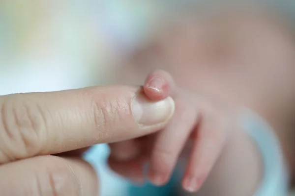 Крупним планом новонароджений палець торкається матерів рука — стокове фото