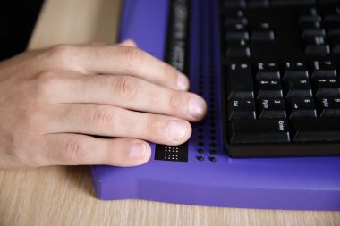 Kör kişi braille bilgisayar ekranı ile bilgisayar kullanarak 