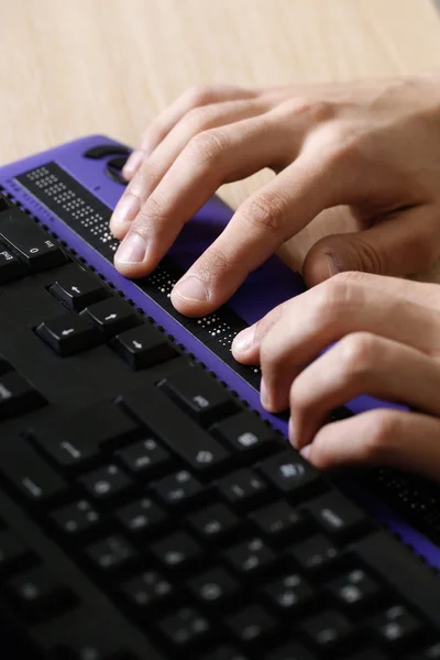 Blind person using computer with braille computer display