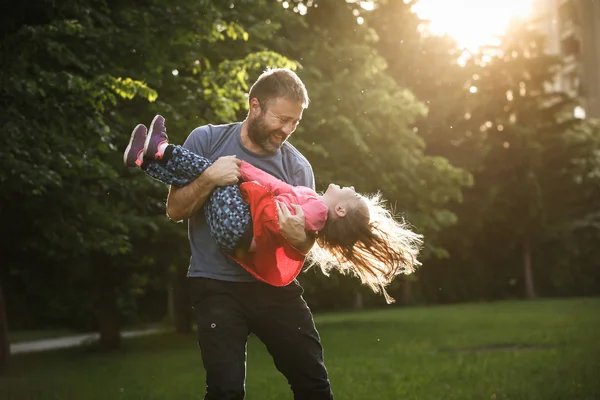 Dedicado pai girando sua filha em círculos — Fotografia de Stock