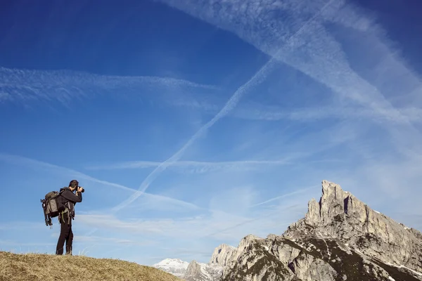 Caminante fotógrafo tomando fotos en una cima de la montaña — Foto de Stock