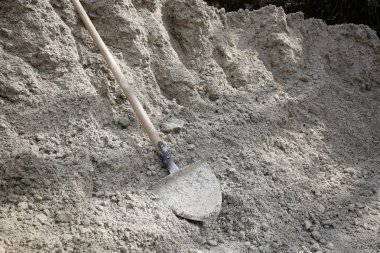 İnşaat malzeme yığını üzerinde yalan kürek