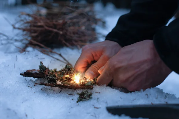 人在黑暗的冬天的森林里生火 — 图库照片