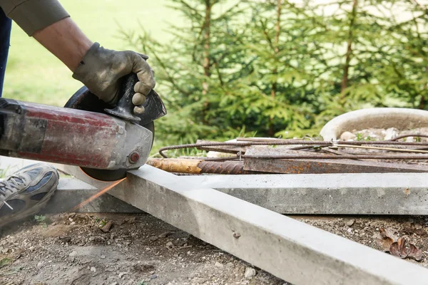 Trabajador de la construcción cortando un pilar de hormigón armado — Foto de Stock