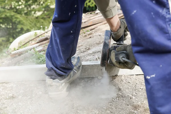 Trabajador de la construcción cortando un pilar de hormigón armado — Foto de Stock