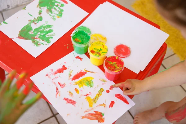 Criança pintando um desenho com pinturas de dedo — Fotografia de Stock