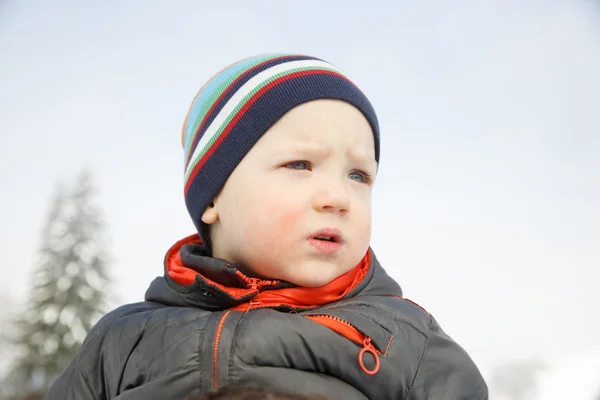 Блакитноокий маленький хлопчик в зимовому пейзажі — стокове фото