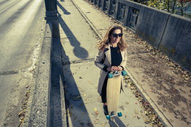 Aktif bir kadın uzun tahtayı tutuyor. Kentsel yaşam tarzı konsepti