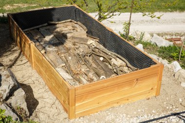 Yükseltilmiş bahçe yatağı için yeni bir ahşap çerçevede dallar ve kütükler. Diy konsepti. Sürdürülebilir yaşam