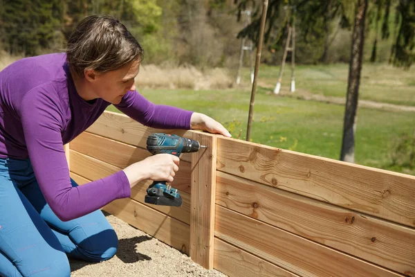 Woman Building Wooden Frame Raised Garden Bed Using Power Drill — Stock Photo, Image