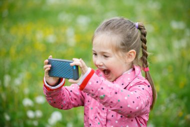 Küçük kız onun smartphone ile fotoğraf çekimi