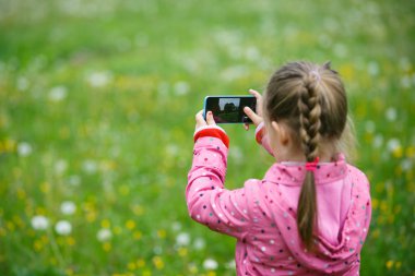Küçük kız doğa onun smartphone ile keşfetmek