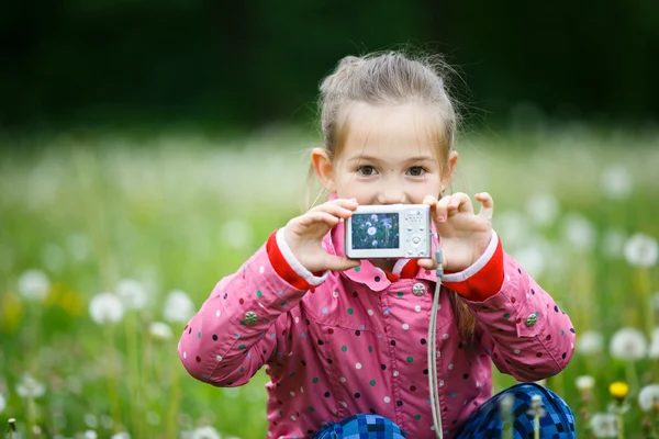 Маленька усміхнена дівчинка з гордістю показує свою фотографію — стокове фото