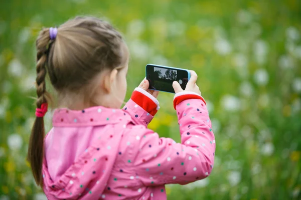 Menina explorando a natureza com seu smartphone — Fotografia de Stock