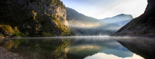 Dağ gölü manzarası kayalık yamaç parlayan güneş ile — Stok fotoğraf