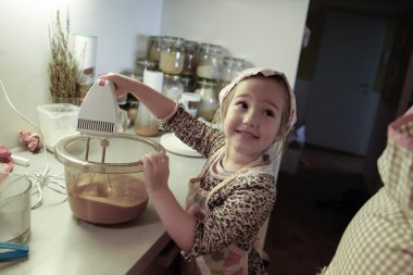 Küçük kız bir doğum günü için pasta hamur karıştırma