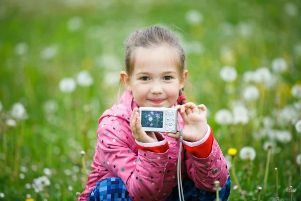 Little smiling girl proudly showing her photograph — Stock Photo, Image