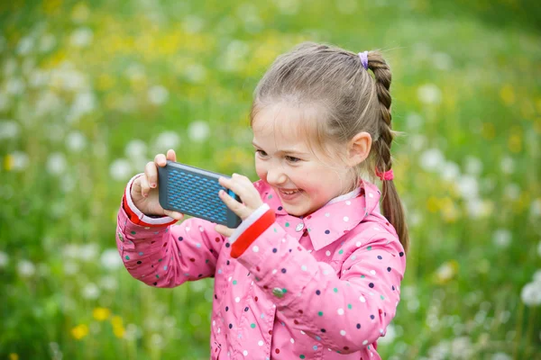 Little girl photographing with her smart phone — Stock Photo, Image