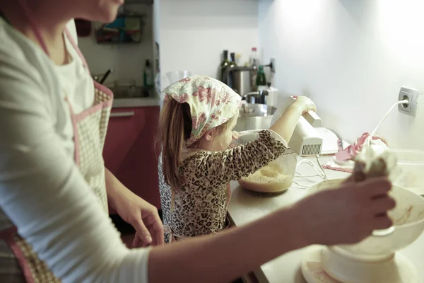 Вагітна жінка і маленька дівчинка готують на кухні — стокове фото