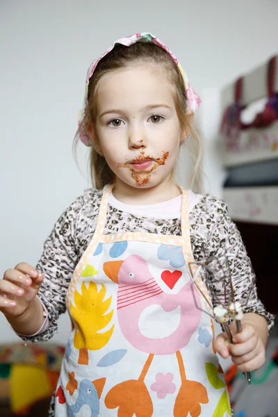 Niña comiendo chocolate del batidor —  Fotos de Stock