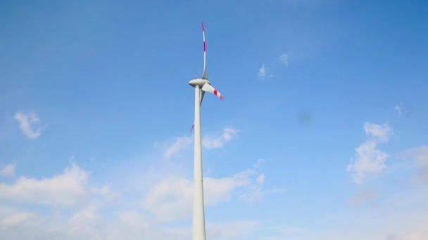 Turbina eoliana impotriva cerului albastru si a norilor albi — Videoclip de stoc