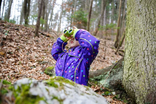 Girl looking through the binoculars — Stock Photo, Image