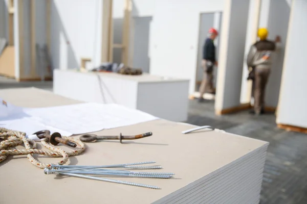 Screws on plasterboard panels with workers — Stock Photo, Image