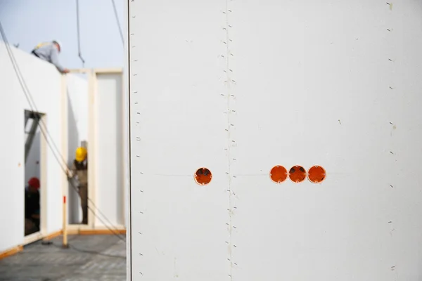 Electricity sockets in a drywall with workers in background — Stock Photo, Image