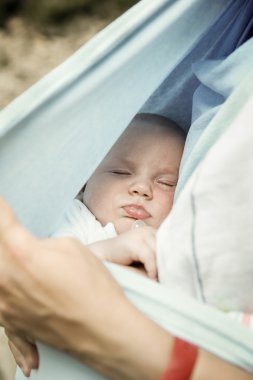 Anneler kollarında dinlenme uyuyan bir bebek çocuk portresi