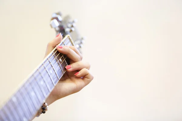 Woman musician holding a guitar, playing a G chord — Stock Photo, Image