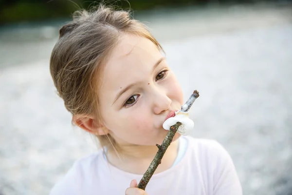 Weinig meisje eten geroosterde marshmallow — Stockfoto
