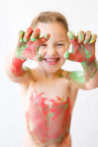 Kleines Mädchen zeigt ihre Hände, bedeckt mit Fingerfarbe — Stockfoto