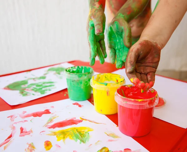 Niños sumergiendo los dedos en pinturas lavables para los dedos —  Fotos de Stock