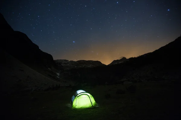 Tenda em pé em um pasto de montanha sob céu estrelado — Fotografia de Stock